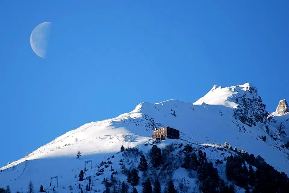 Mondaufgang über der verschneiten Hütte